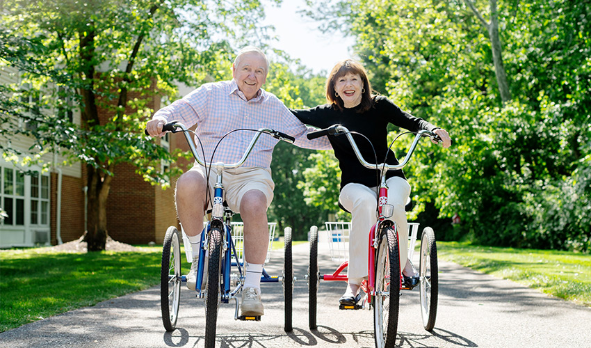 Two people riding bikes together.