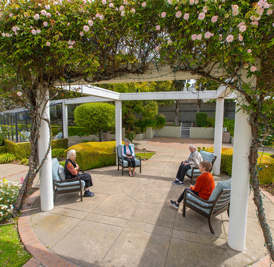 Residents are sitting in a courtyard at Sagebrook Senior Living at San Francisco.