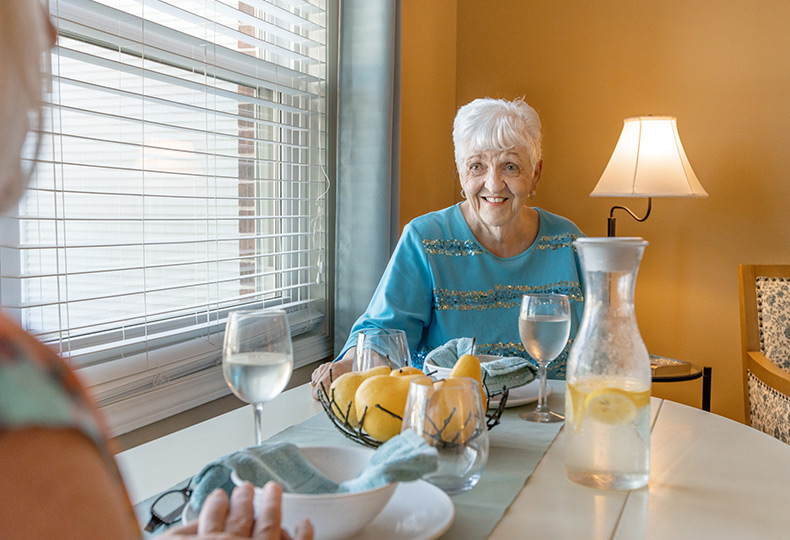 A resident is sitting at table in Sagebrook Senior Living at San Francisco.