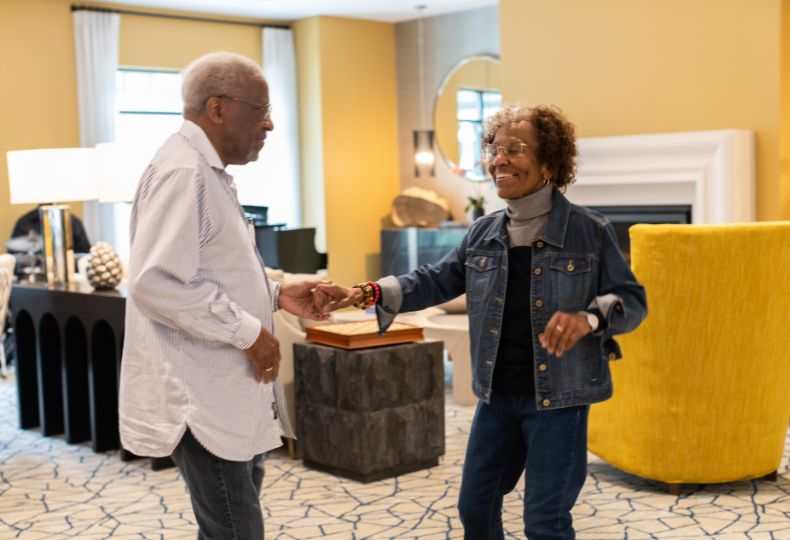 Two residents are dancing at The Sky Bridge at Town Center.