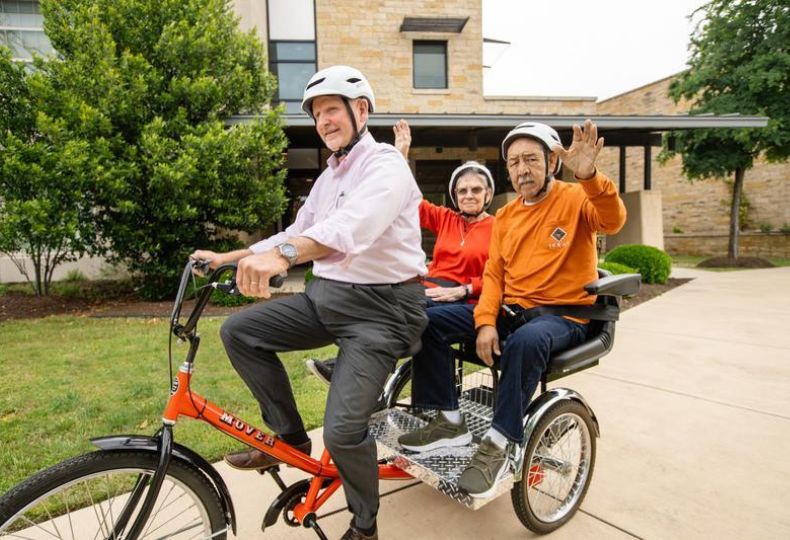 Three residents are riding a tricycle.