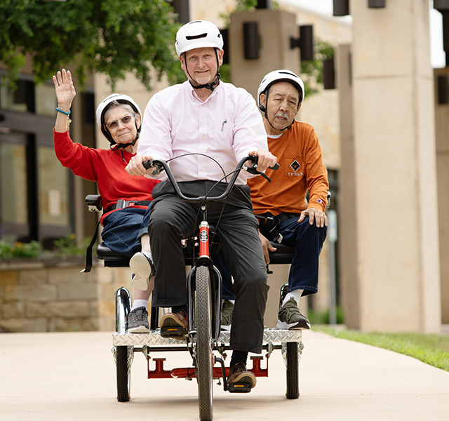 Residents riding on a thricycle.