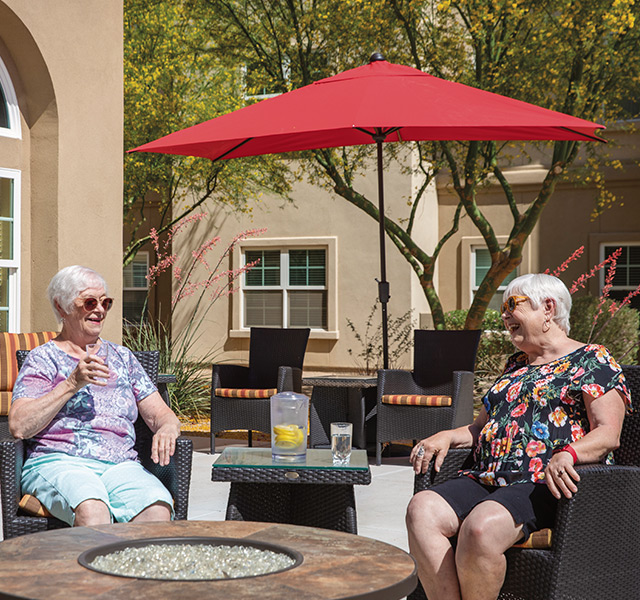 Residents are sitting on a patio at St. Andrews Village.