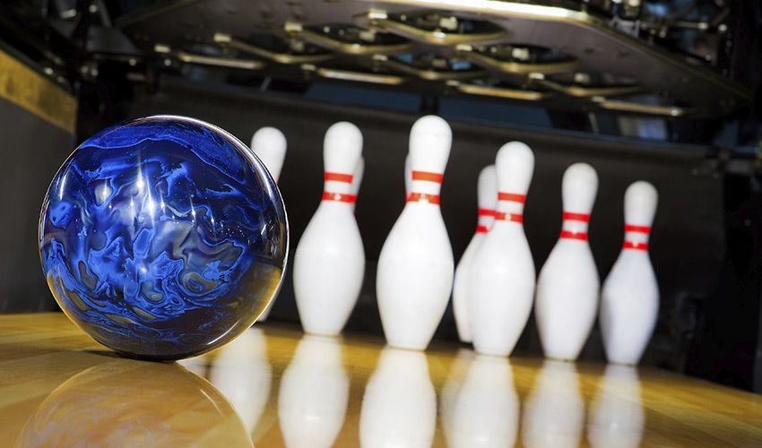 A blue bowling ball and pins.