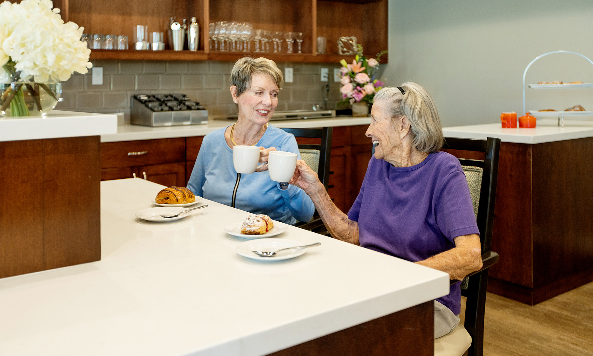 Two residents are at the cafe bar enjoying coffee and breakfast.