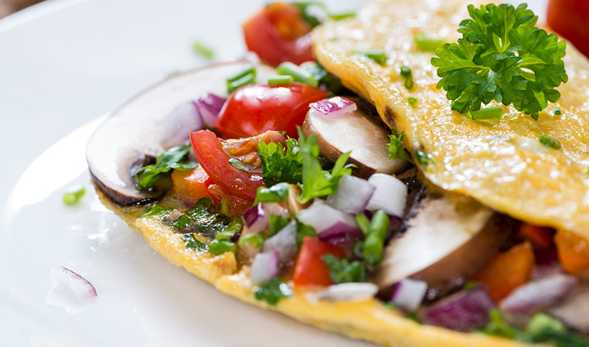 An open faced omelet filled with vegetables.