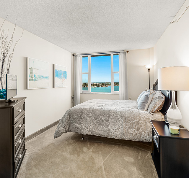 Fully furnished bedroom with a water view from the window.