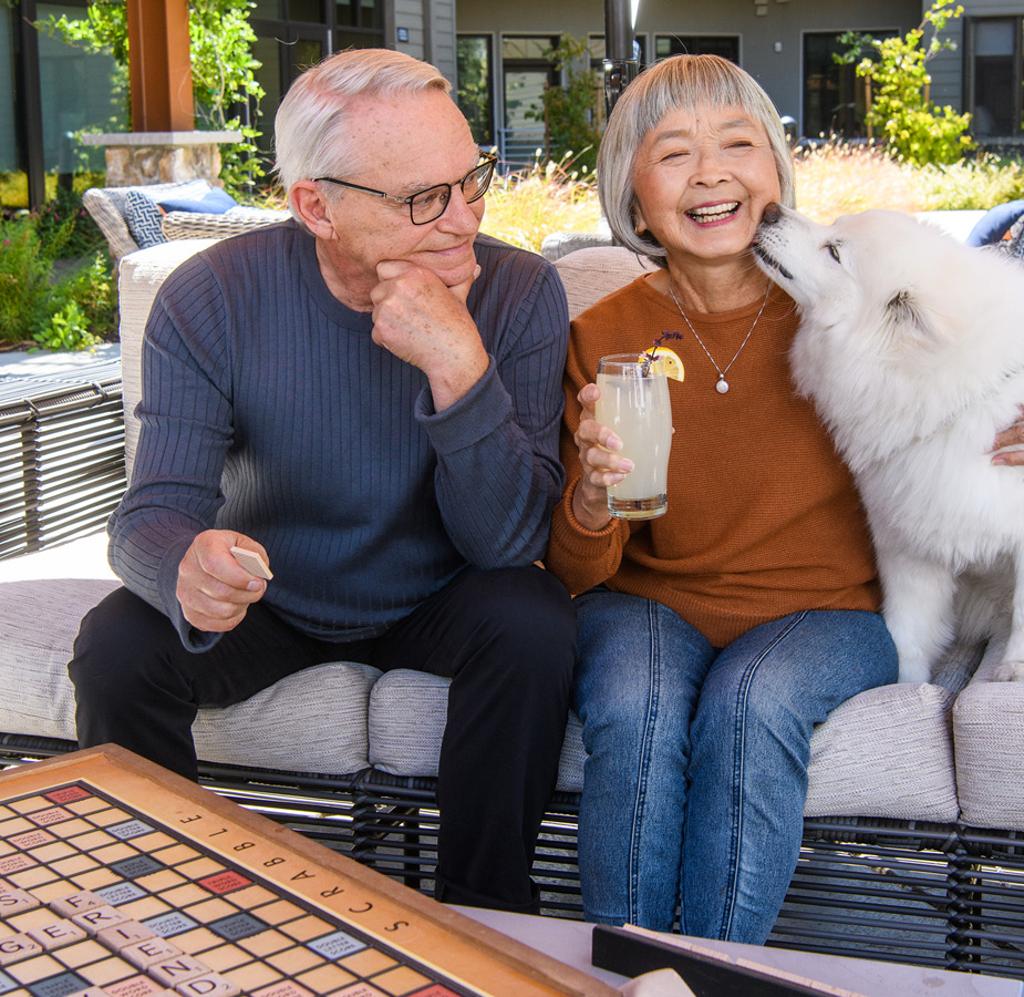 Two residents are outside with their dog playing a letters game.
