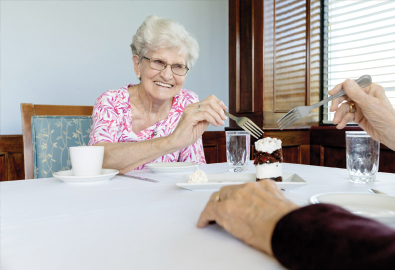 A resident is eating a dessert.