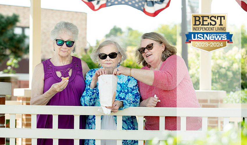 Three friends eating popcorn in a gazebo.