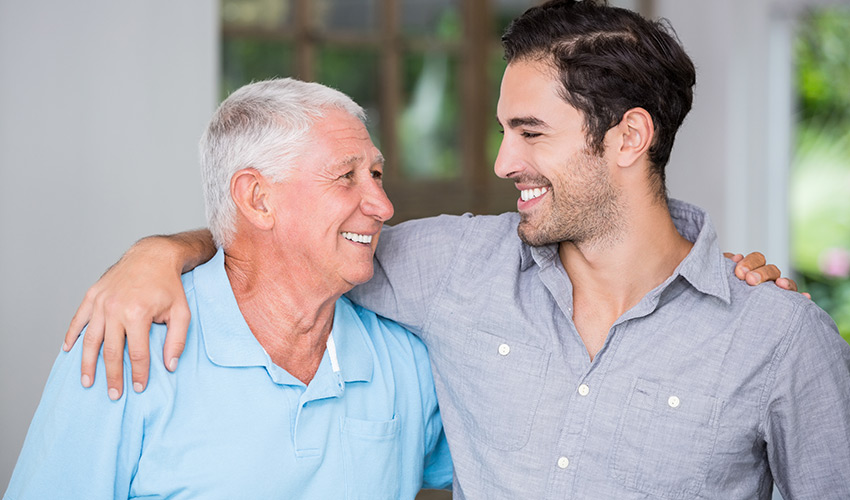 A father and son with arms around each other.