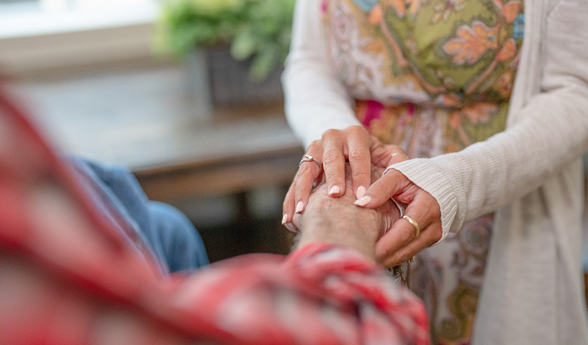 A woman holding a man's hands.