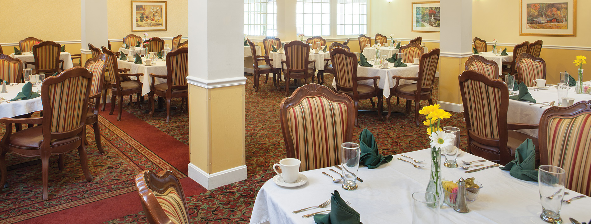 A dining room with tables and chairs.