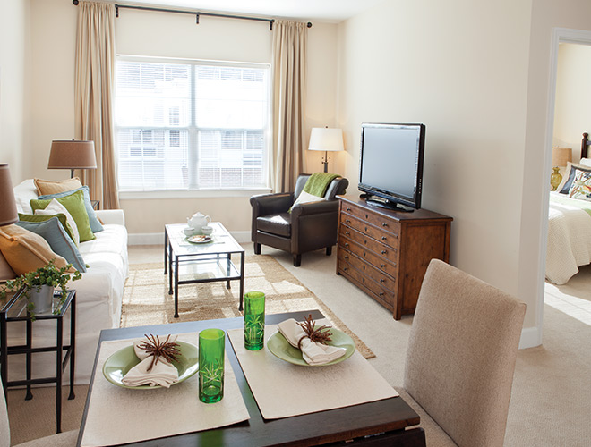 Furnished living room space with sofa, table, and seating area.