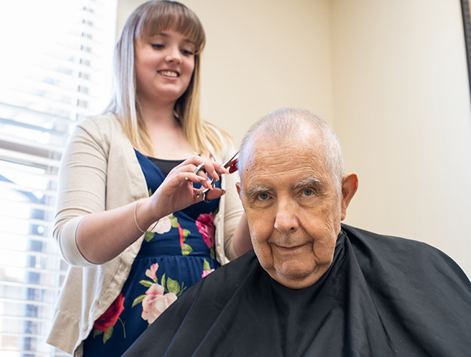 elderly man getting a haircut at salon