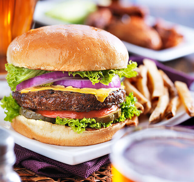 Plate with a juicy cheeseburger and fries.