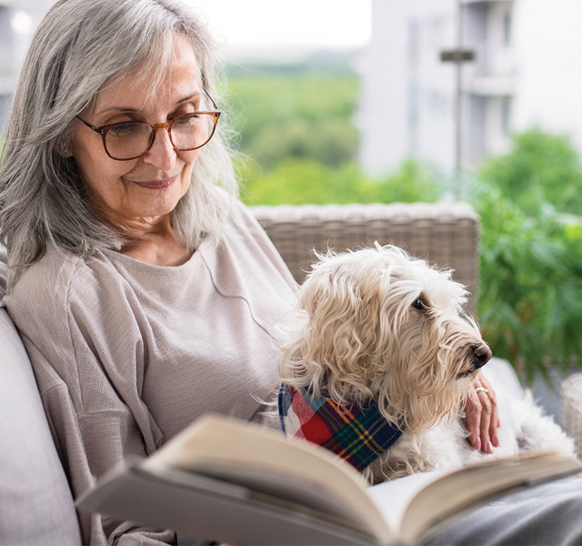 A resident with their dog reading a book.