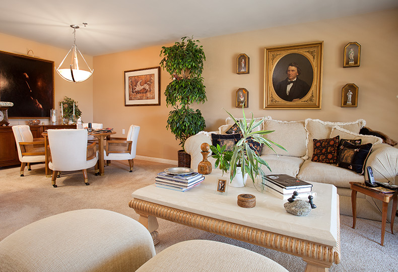 living space with a light beige sofa, coffee table and dining room table and chairs on the left