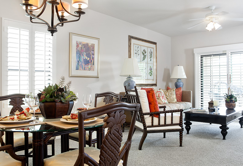side view of dining room table with chairs and sofa, coffee table and bright sliding galss doors behind
