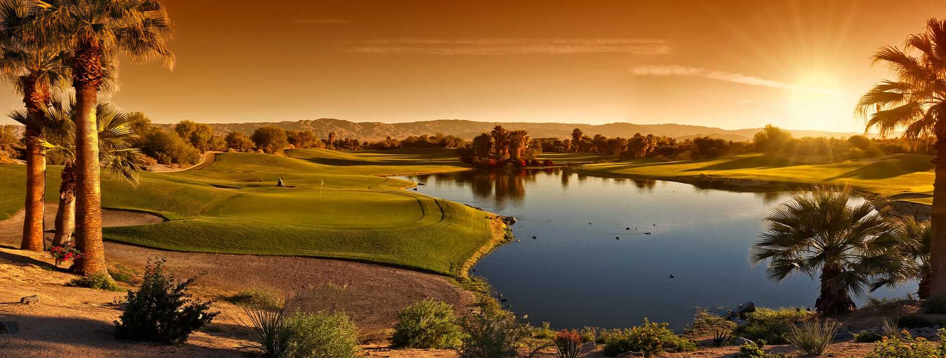scenic view of golf course and lake at sunset