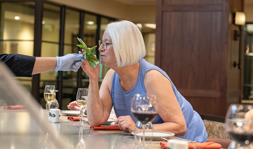 A person smelling an herb.