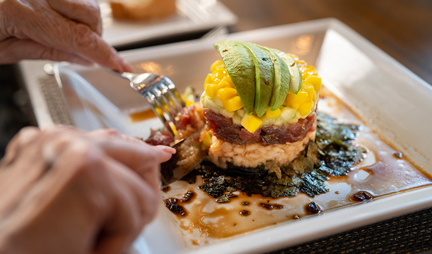 A person cutting into their dinner.