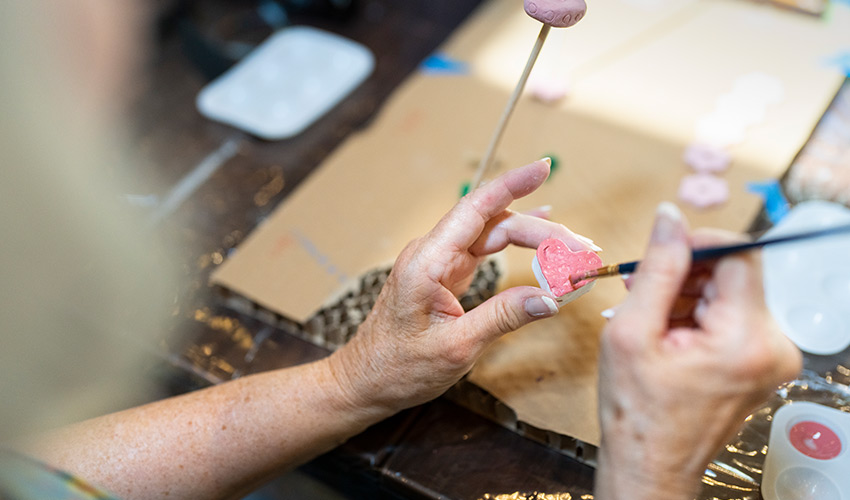 A person painting a heart pink.