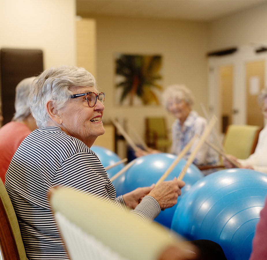 A person drumming on a large rubber ball.