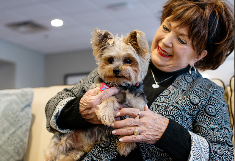 A resident holding a small dog.