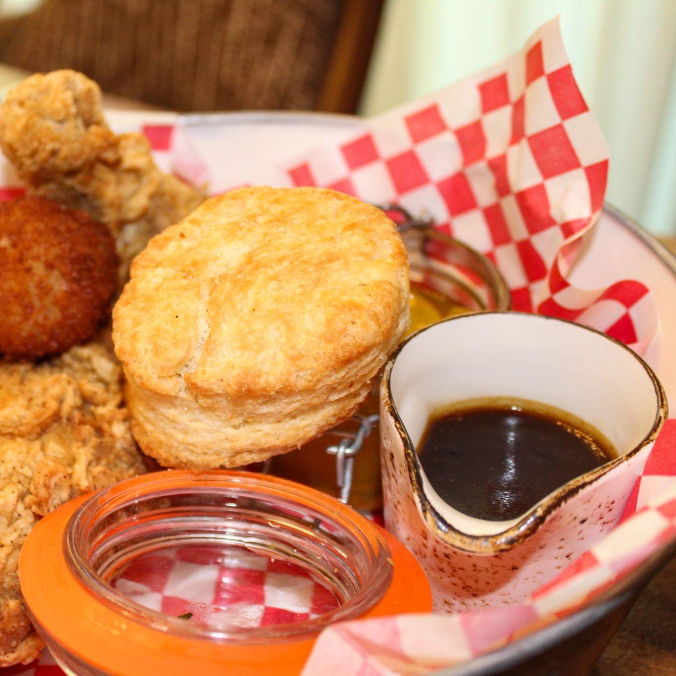 Fried chicken, biscuits and syrup in a basket