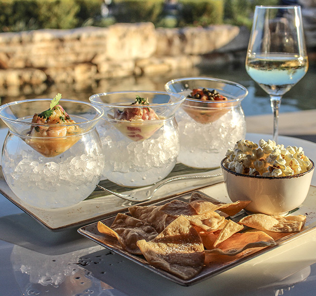 Food and wine on a table outside.