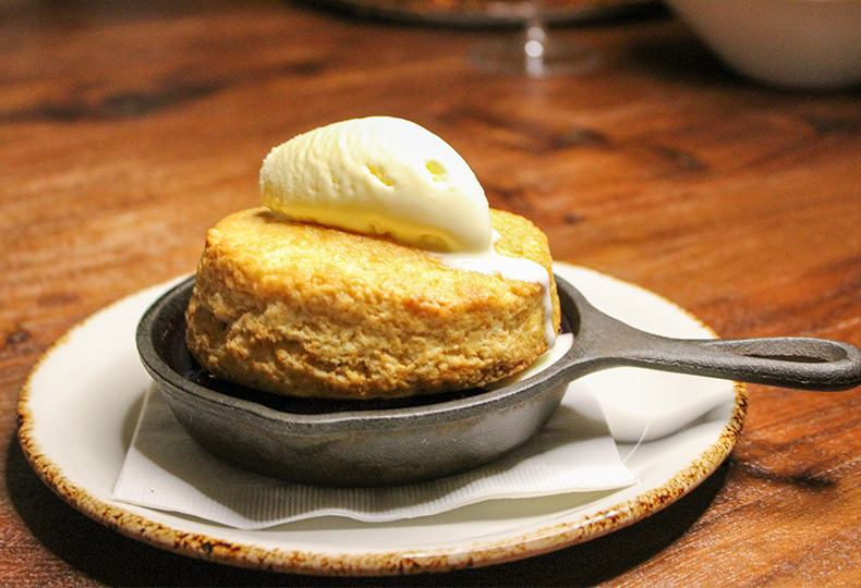 A skillet corn bread with butter on top.