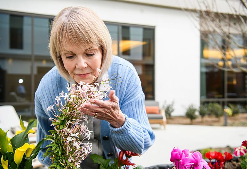 A resident smells flowers.