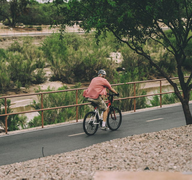 A resident enjoying an outdoor bike ride on an outdoor pathway in Tucson, AZ.