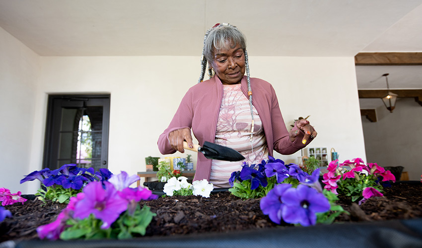 An african american woman working at a gardening bench.