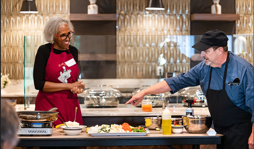 Two people cooking in a kitchen.