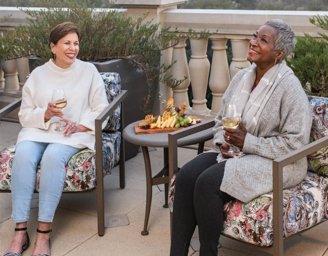 Residents sitting out in the patio by a fire.