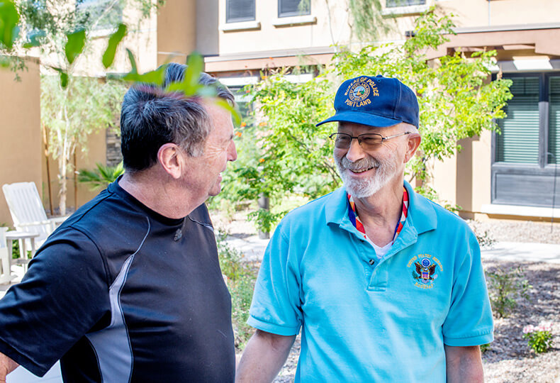 two residents standing and chatting outside