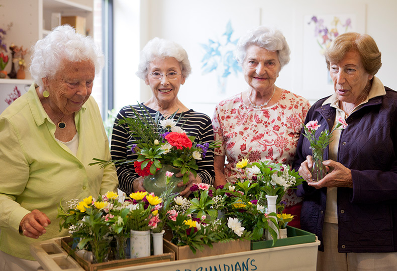 a group of residents looking at floral arrangements