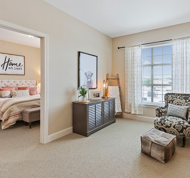 view of one bedroom unit with a chair, bright window and bed