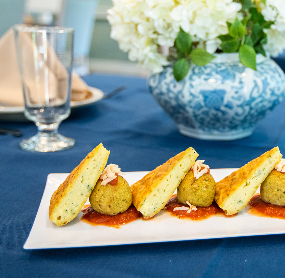 a close up of a plate of food consisting of meat ball and an egg bake dish