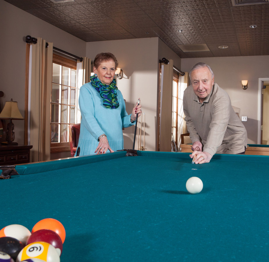 Two residents are playing a game of pool.