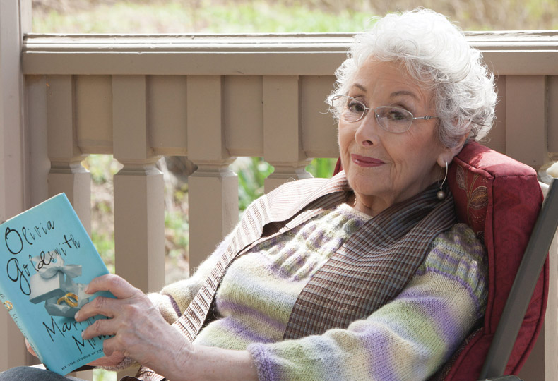 A resident is on the porch reading a book.