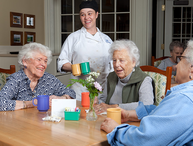 Three residents are sitting in the dining area together.