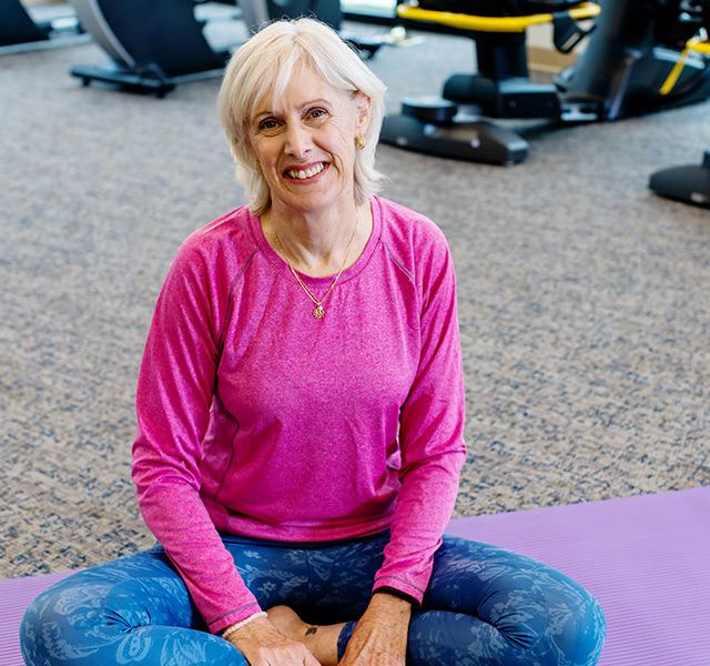 A person sitting on the floor in the gym.