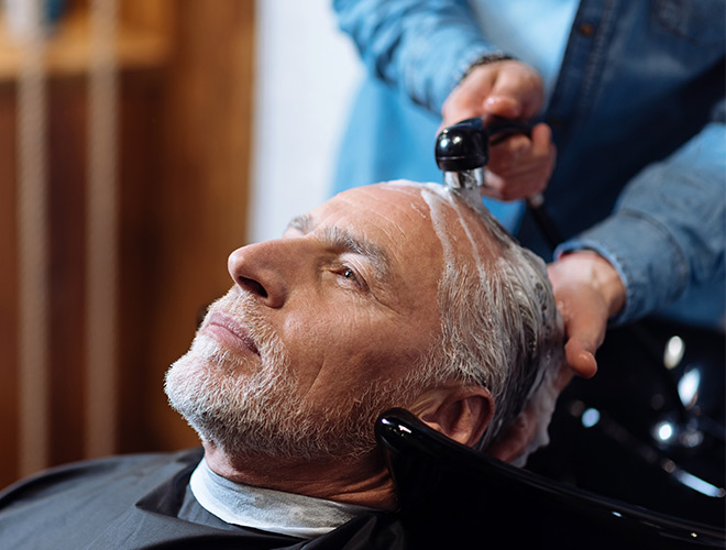 A resident is having their haircut in the salon.