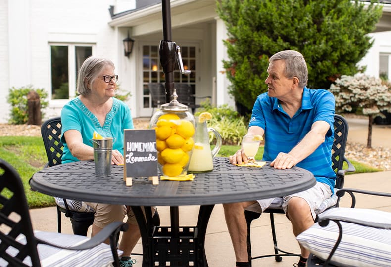 Residents are sitting on the patio at The Watermark at St. Peters.