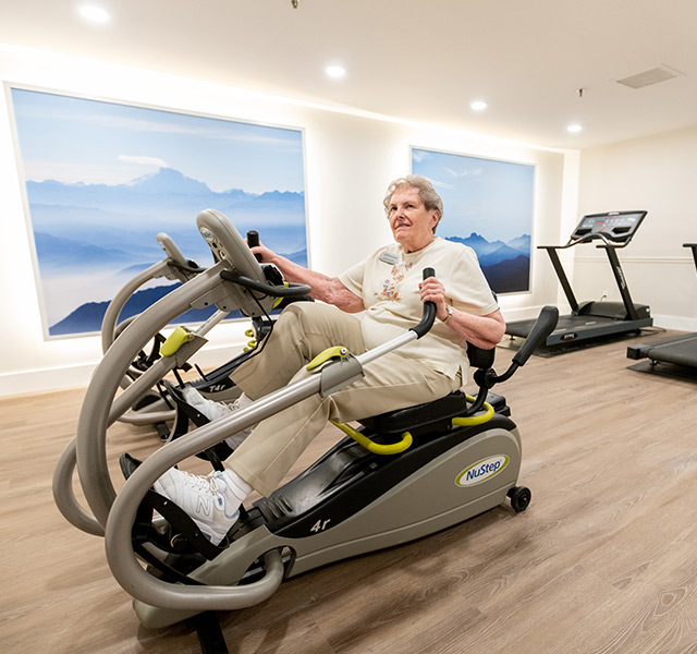 A resident is on a fitness machine.