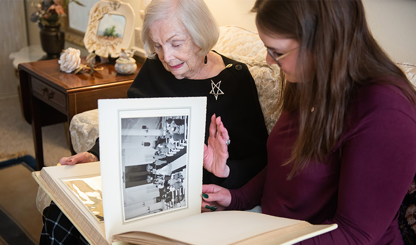 two people sitting and flipping through a photo album