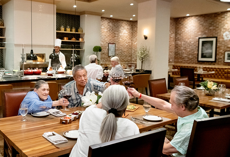 Four residents are eating together in the dining area.